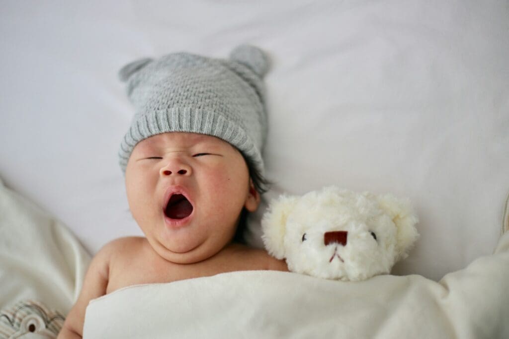 Baby der sover med sin bamse